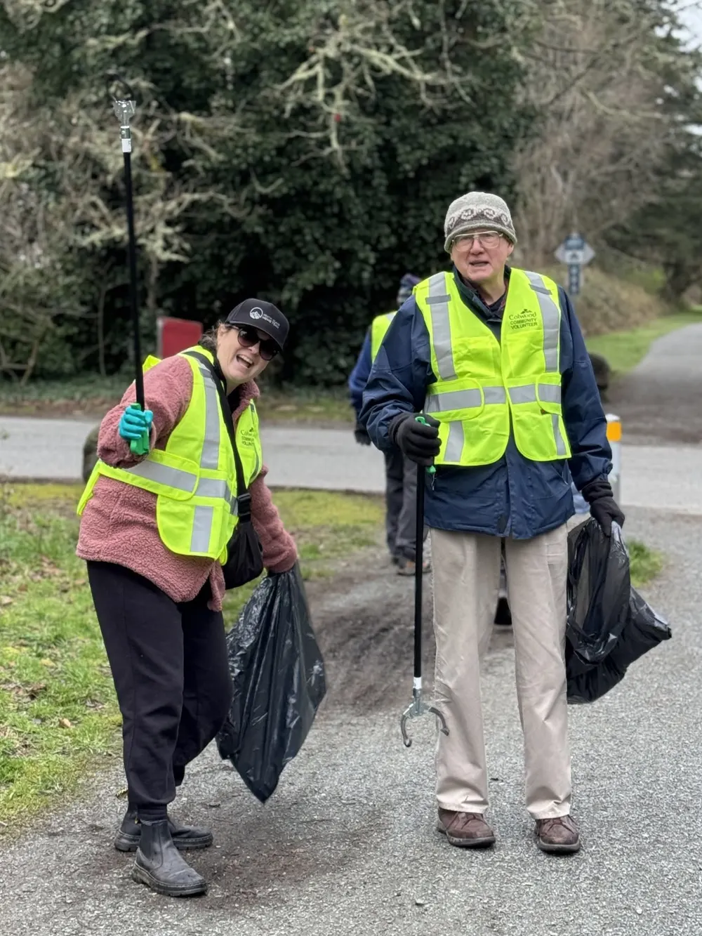 Members in safety vests picking up litter on a community cleanup