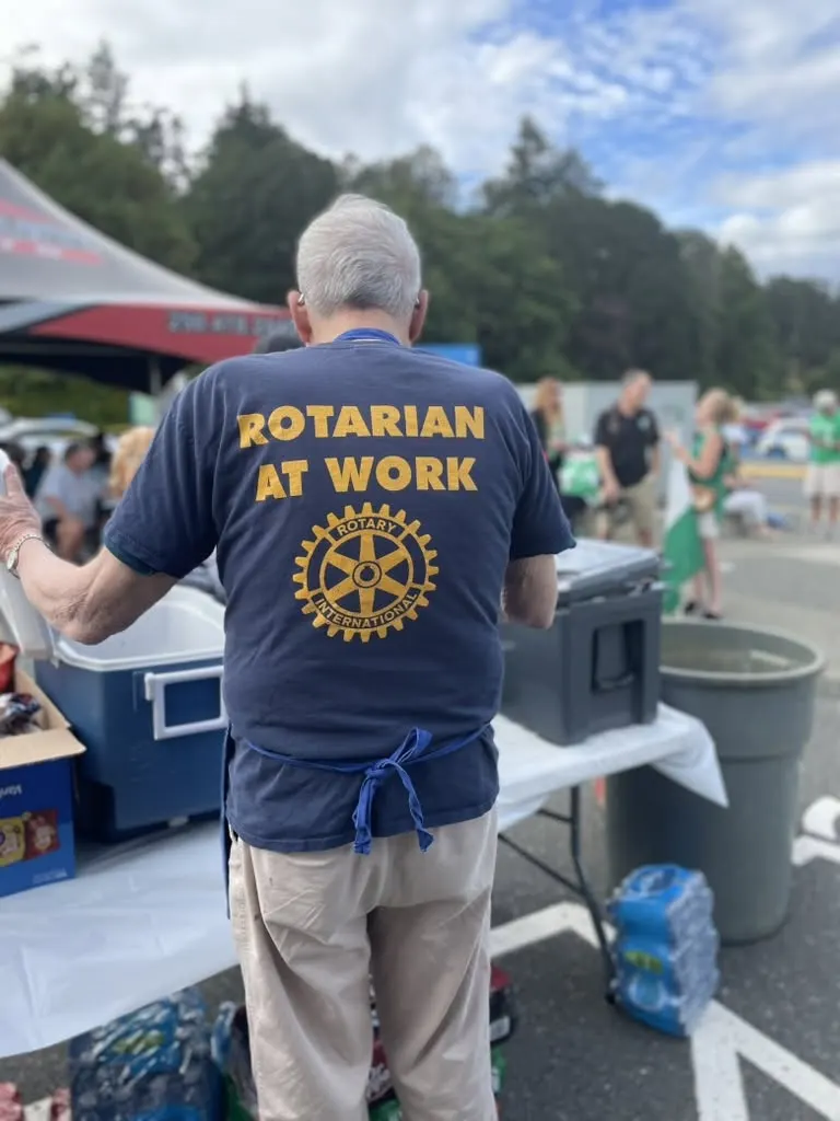 A member wearing a Rotarian at Work t-shirt at a fundraising booth